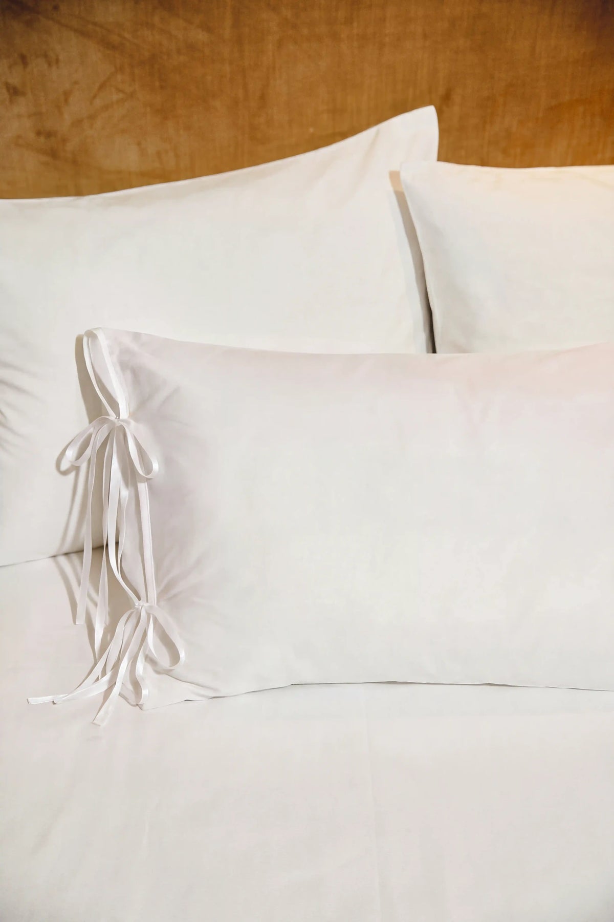 Camille Ribbons Satin Pillowcase in White featuring delicate ribbon details and a luxurious satin finish