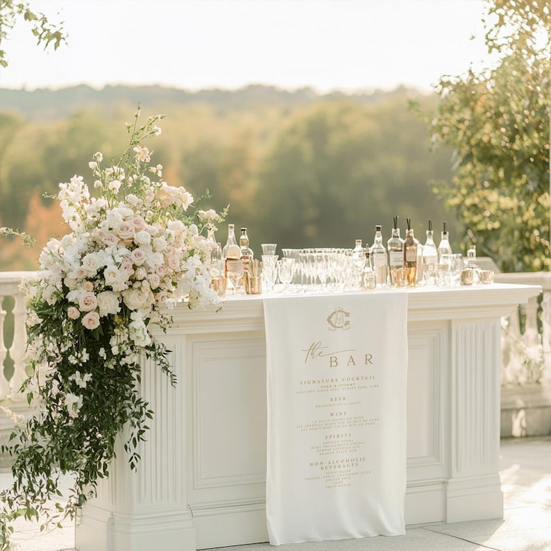 Decorative outdoor bar setup with flowers and bottles on a sunny day.